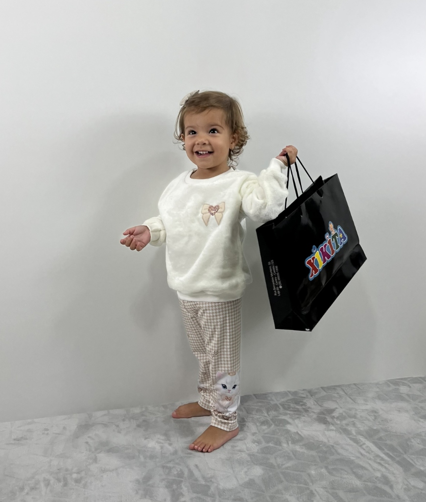 Criança sorrindo com sacola de compras Xikita